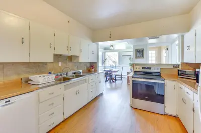 a large kitchen with white cabinets and a wooden floor at Historic Manor 3 Mi to Shawnee Mtn! Pet Friendly in East Stroudsburg