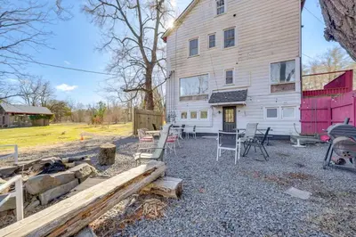 a white house with a table and chairs in front of it at Historic Manor 3 Mi to Shawnee Mtn! Pet Friendly in East Stroudsburg