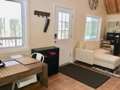 a living room with a couch and a table at Beautiful Lakefront Chalet in the Poconos! in Hawley