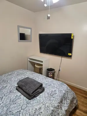 a bedroom with a bed and a flat screen tv at Honey queen room 5 in Newark