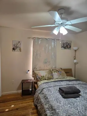 a bedroom with a ceiling fan and a bed at Honey queen room 5 in Newark