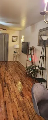 a living room with wooden floors and a flat screen tv at Amazing family house in Newark