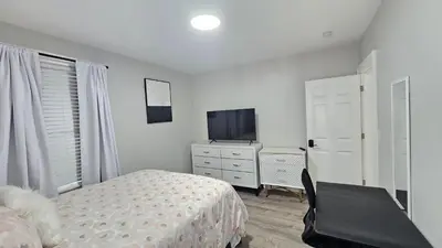 a bedroom with a bed and a tv and a dresser at Room for rent shared apartment in Hartford