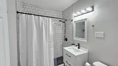 a white bathroom with a shower and a sink at Room for rent shared apartment in Hartford