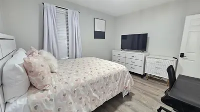 a bedroom with a bed and a flat screen tv at Room for rent shared apartment in Hartford