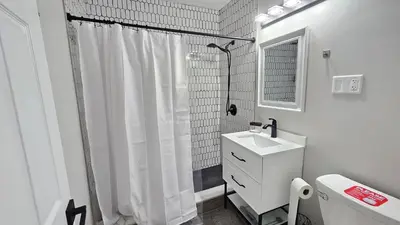 a white bathroom with a shower curtain and a sink at Room for rent shared apartment in Hartford