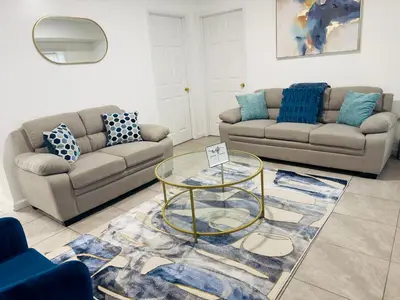 a living room with two couches and a glass table at Cosy Bedroom 6 minutes to EWR Prudential Hotels Pen station in Newark