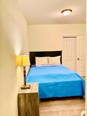 a bedroom with a bed and a lamp on a table at Penn Station Room Motel Casa in Newark