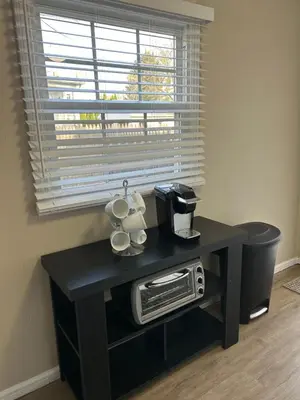 a black table with two mugs and a microwave at Charming Cottage with fenced yard in convenient location in Longmeadow