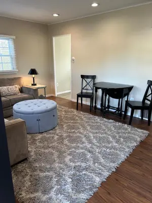 a living room with a couch and a table at Charming Cottage with fenced yard in convenient location in Longmeadow