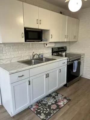 a kitchen with a sink and a microwave at Charming Cottage with fenced yard in convenient location in Longmeadow