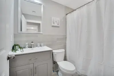 a white bathroom with a toilet and a sink at Your home away from home in Newark