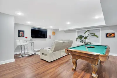 a living room with a pool table and a chair at Your home away from home in Newark