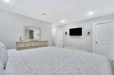 a white bedroom with a large bed and a mirror at Home away from home 2 in Newark