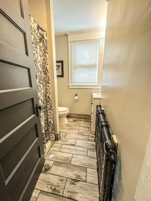 a bathroom with a toilet and a door at The Red House Albany NY 4 Bedroom Private Apartment in Albany