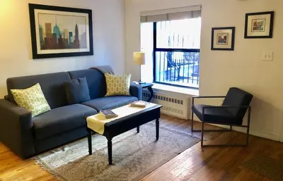a living room with a blue couch and a table at Top Rated 1BR - Lenox 127 in New York