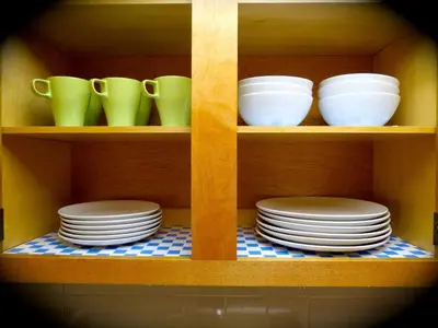 a shelf with plates and cups and dishes on it at Top Rated 1BR - Lenox 127 in New York