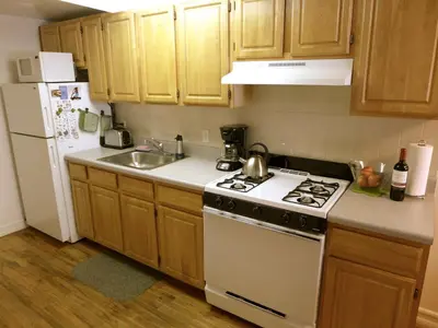 a kitchen with a white stove top oven next to a sink at Top Rated 1BR - Lenox 127 in New York