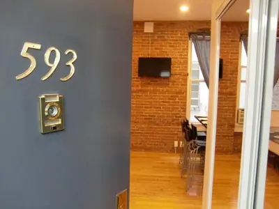a clock on a wall next to a dining room at Studios Midtown Manhattan in New York