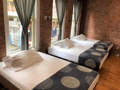 two beds in a room with two windows at Studios Midtown Manhattan in New York