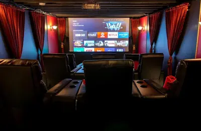 a room with chairs and a large screen in a theater at Incredible New York Cabin with a Spa and Movie Theater in Livingston Manor