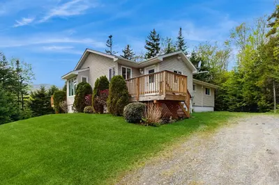 a house with a deck on a green lawn at Ski Dreams in Dover