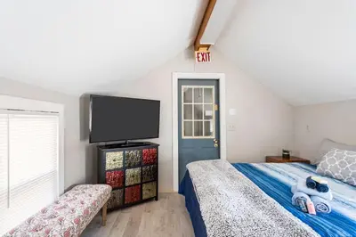 a bedroom with a bed and a flat screen tv at Heart of Historic Wurtsboro Suite 6 in Wurtsboro