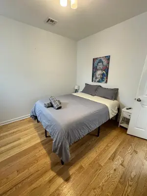 a bedroom with a large bed and a wooden floor at 4 ROOMS FAMILY HOUSE WITH BACKYARD, LAUNDRY AND PARKINg in Union City
