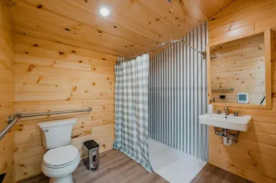 a wooden bathroom with a toilet and a sink at Classic Safari Tent in the Heart of the Adirondack Wilderness, near Lake George, New York in Corinth