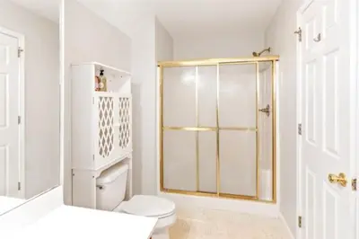 a white bathroom with a shower and a toilet at Hilltop Villa in East Stroudsburg