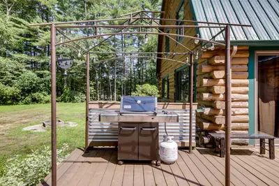 a patio with a table with a laptop on it at 3 Mi to UMass Amherst Peaceful New England Cabin in Sunderland