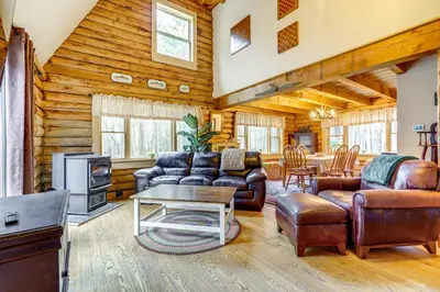 a living room with leather furniture in a log cabin at 3 Mi to UMass Amherst Peaceful New England Cabin in Sunderland