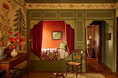 a bedroom with an orange wall and a chair at Six Bells Countryside Inn in Rosendale