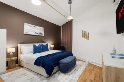 a bedroom with a bed with blue pillows at Beautifully designed 3 BDR in Dumbo NYC in Brooklyn