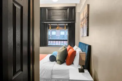 a bedroom with a bed with pillows and a window at NYC Apartment in The Best Location! Walking Distance to Everything! in New York