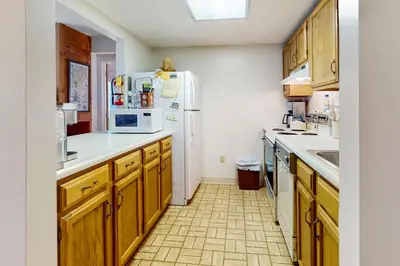a kitchen with wooden cabinets and a white refrigerator at Snow Tree 337H in Dover