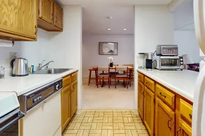 a kitchen with wooden cabinets and a dining room with a table at Snow Tree 337H in Dover