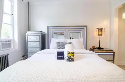 a bedroom with a large white bed and a window at Fireflies In NYC, Cozy, Private & New in Union City