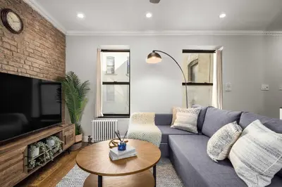 a living room with a couch and a tv at Stylish NYC Retreat Near Top Attractions in New York