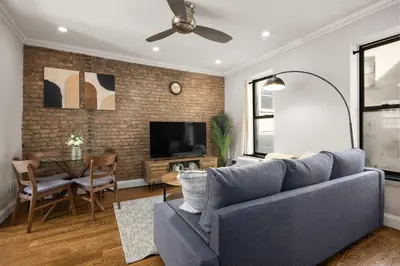 a living room with a blue couch and a table at Stylish NYC Retreat Near Top Attractions in New York
