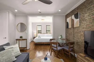 a living room with a bed and a couch and a table at Stylish NYC Retreat Near Top Attractions in New York