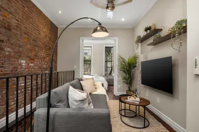 a living room with a couch and a brick wall at Sophisticated Stay in Vibrant Manhattan in New York