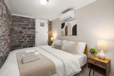 a bedroom with a large white bed and a brick wall at Sophisticated Stay in Vibrant Manhattan in New York