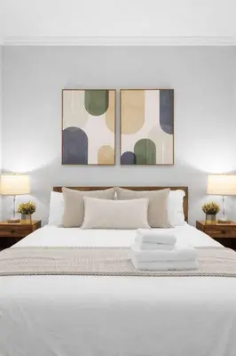 a bedroom with a large white bed with two lamps at Modern Manhattan Haven Near Everything in New York