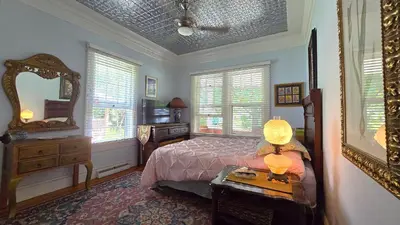 a bedroom with a bed and a table with a mirror at 1920s Phoenicia Bungalow with Vintage Furnishings, Sauna, Fireplace, & Fenced Backyard in Phoenicia