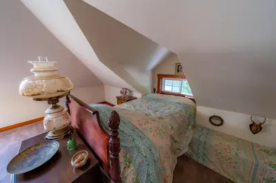 a bedroom with a bed and a table with a lamp at 1920s Phoenicia Bungalow with Vintage Furnishings, Sauna, Fireplace, & Fenced Backyard in Phoenicia