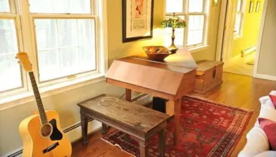 a living room with a guitar and a table at Unique Ski Rental in Berkshires Charlemont Near Hawley State Forest, Plainfield, Western Massachusetts in Plainfield
