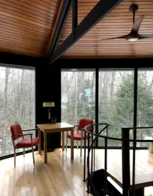 a room with a table and chairs and windows at Imaginative Octogonal Glass Treehouse on Seven Private Acres near Great Barrington, MA in Great Barrington