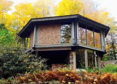 a house with windows on top of a field at Imaginative Octogonal Glass Treehouse on Seven Private Acres near Great Barrington, MA in Great Barrington