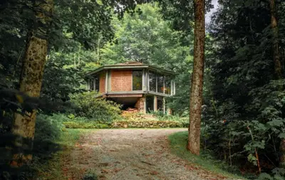 a house in the middle of a forest at Imaginative Octogonal Glass Treehouse on Seven Private Acres near Great Barrington, MA in Great Barrington
